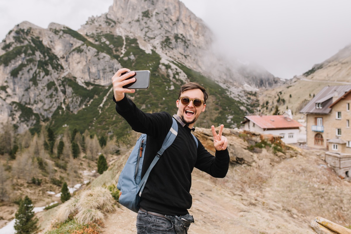 young-man-posing-mountains-with-cozy-house.jpg